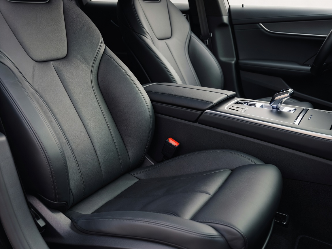 Beautifully clean car interior with high focus on detailed leather seats and modern gear selector console